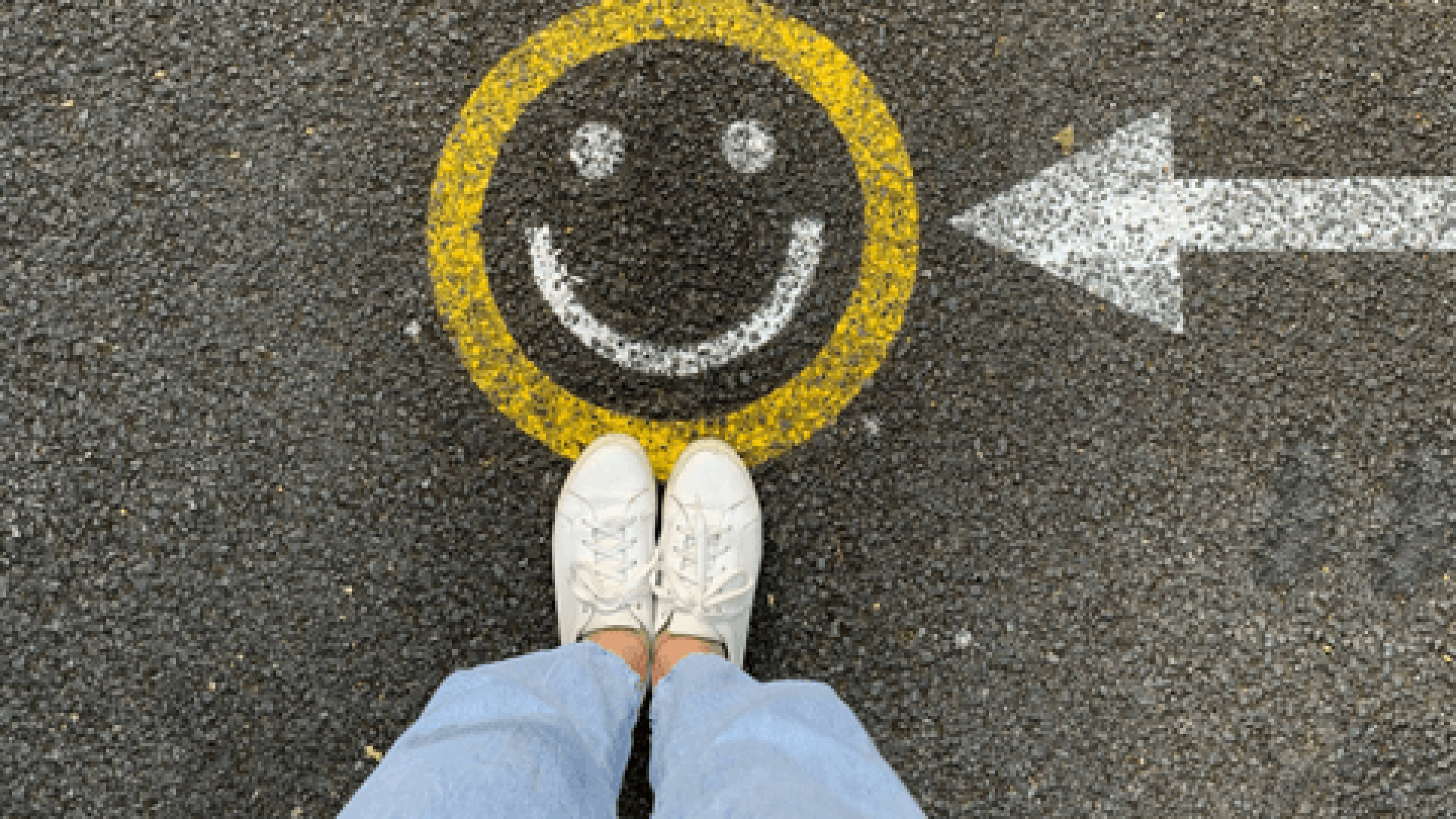 Aufsicht auf Smiley, der auf den Asphalt gemalt ist